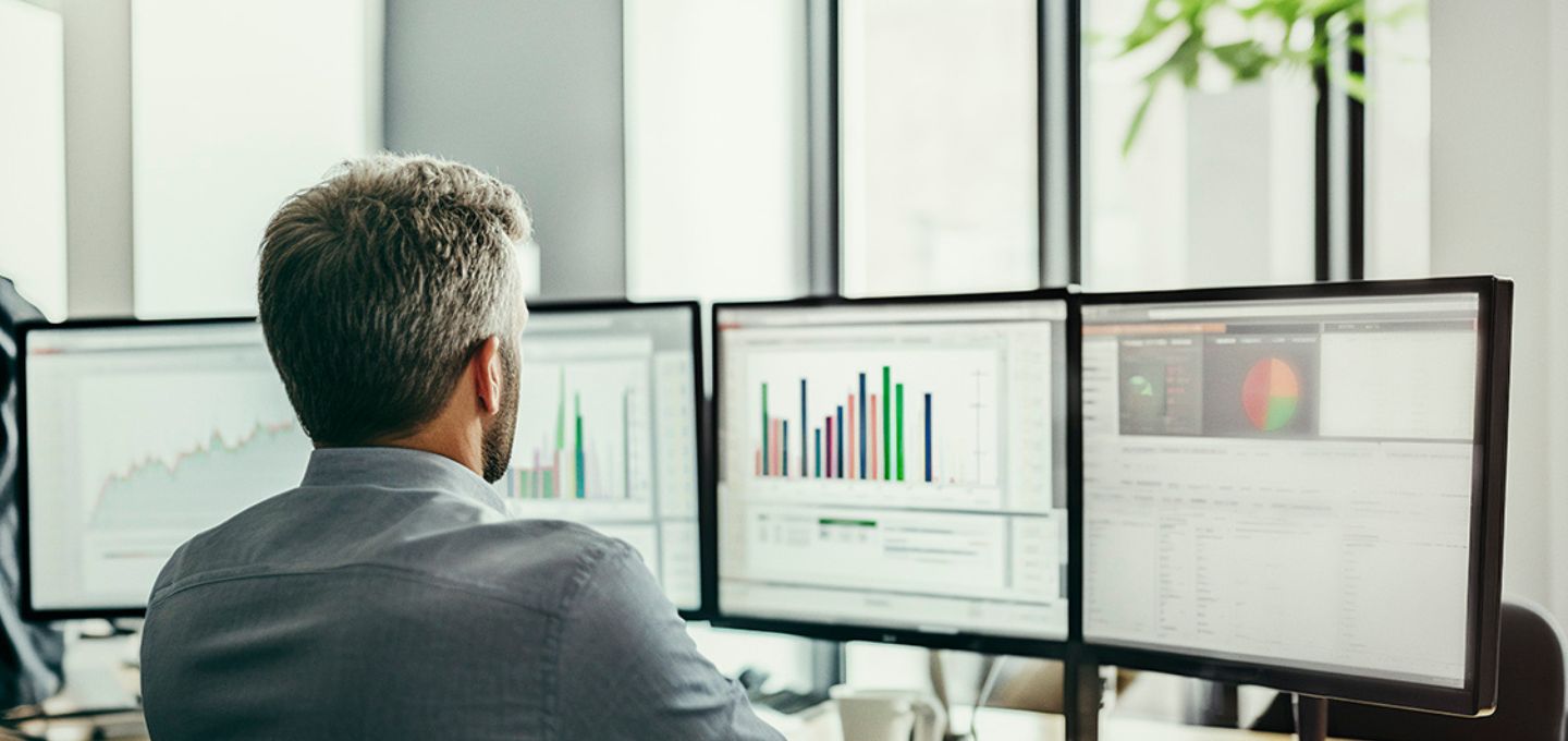 Eine Person schaut auf mehrere Computerbildschirme