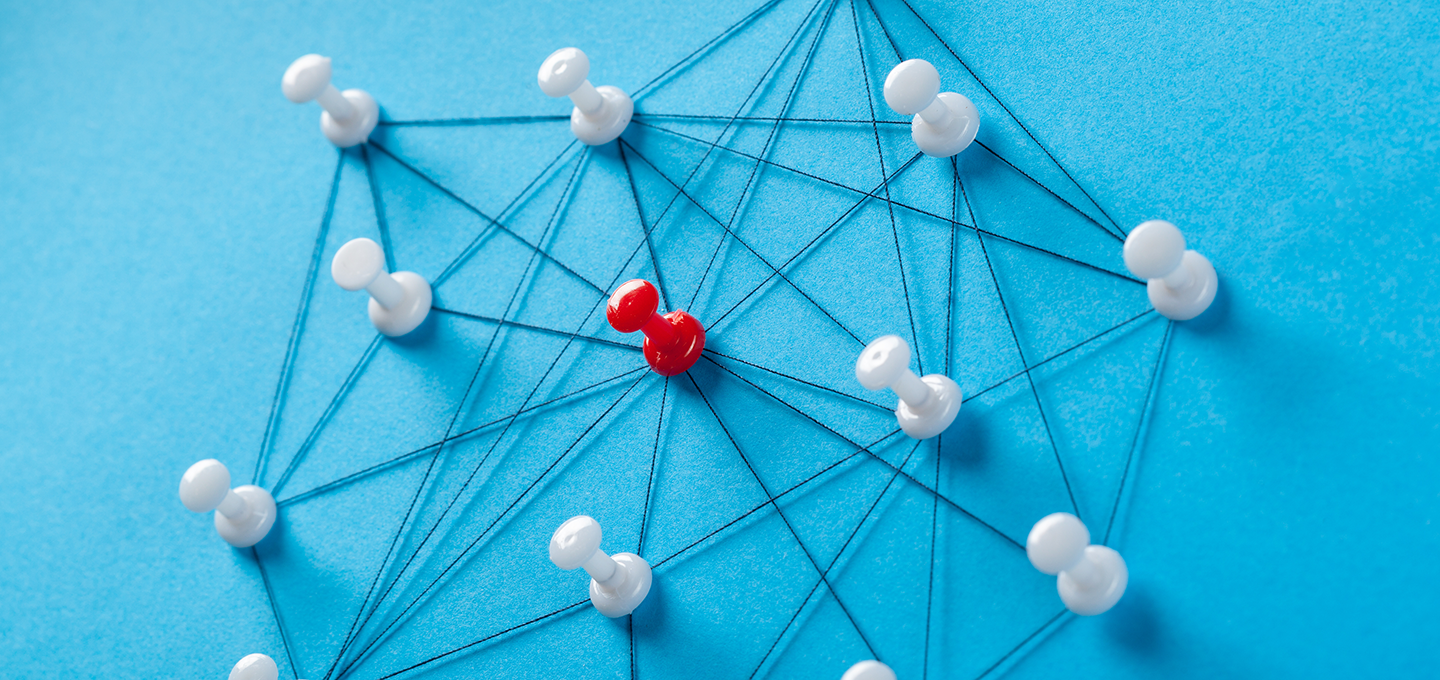 A red pin in a group of white pins