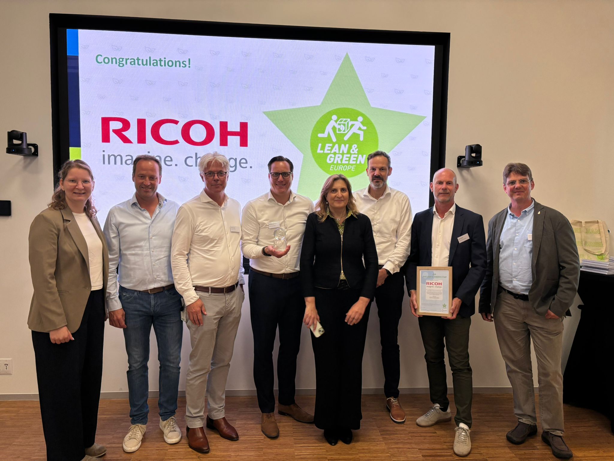 Mitarbeitende bei der Übergabe der Lean & Green Europe-3-Sterne-Zertifizierung